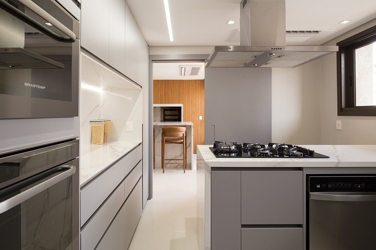 Da cozinha, é possível avistar a bancada de bar e da churrasqueira